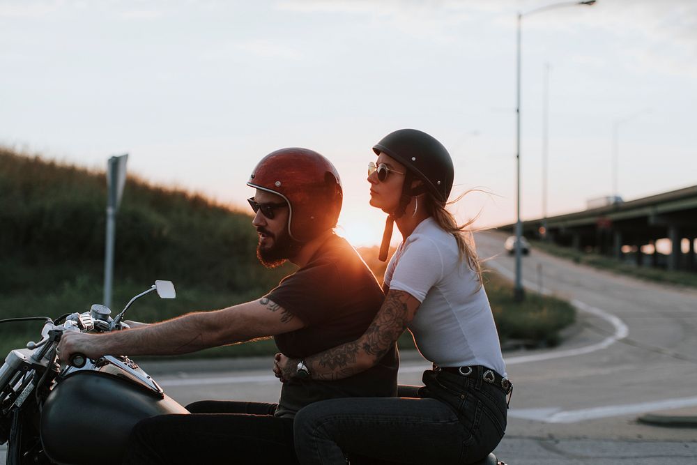 Biker couple riding down the road in the sunset