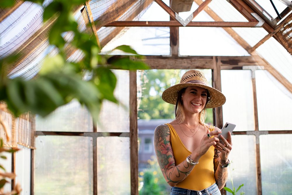 Gardener using her phone in the greenhouse