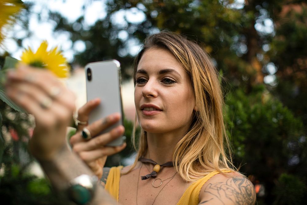 Woman taking a photo of a sunflower