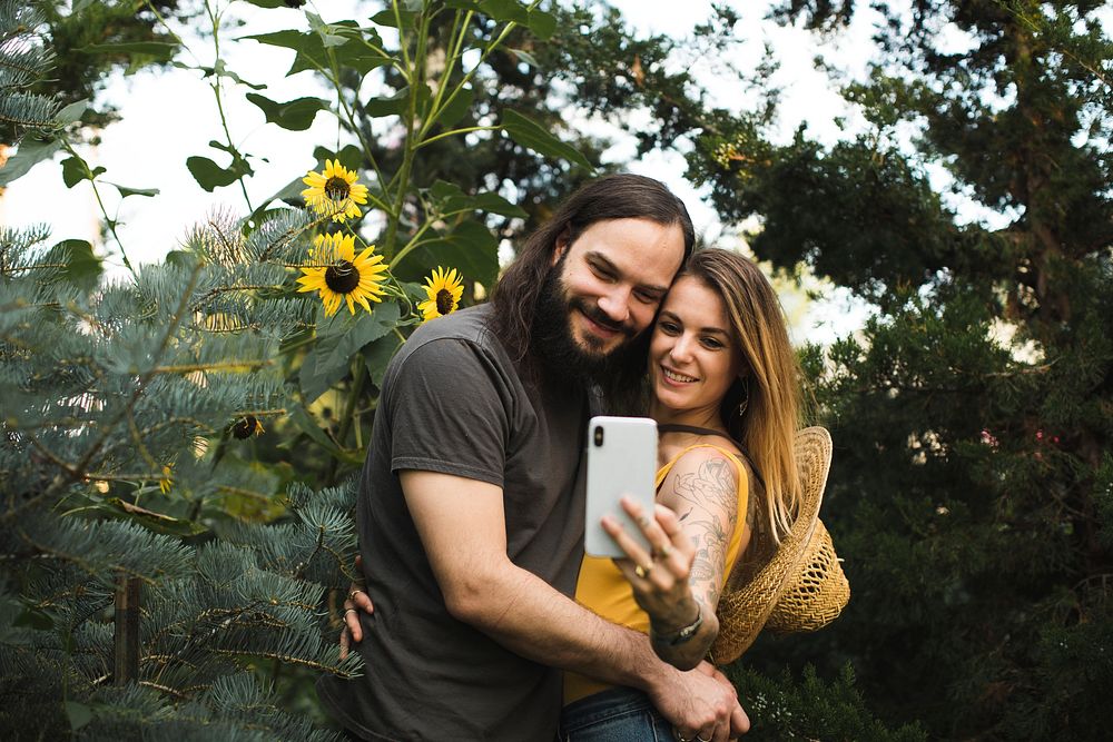 Couple taking a selfie with sunflowers