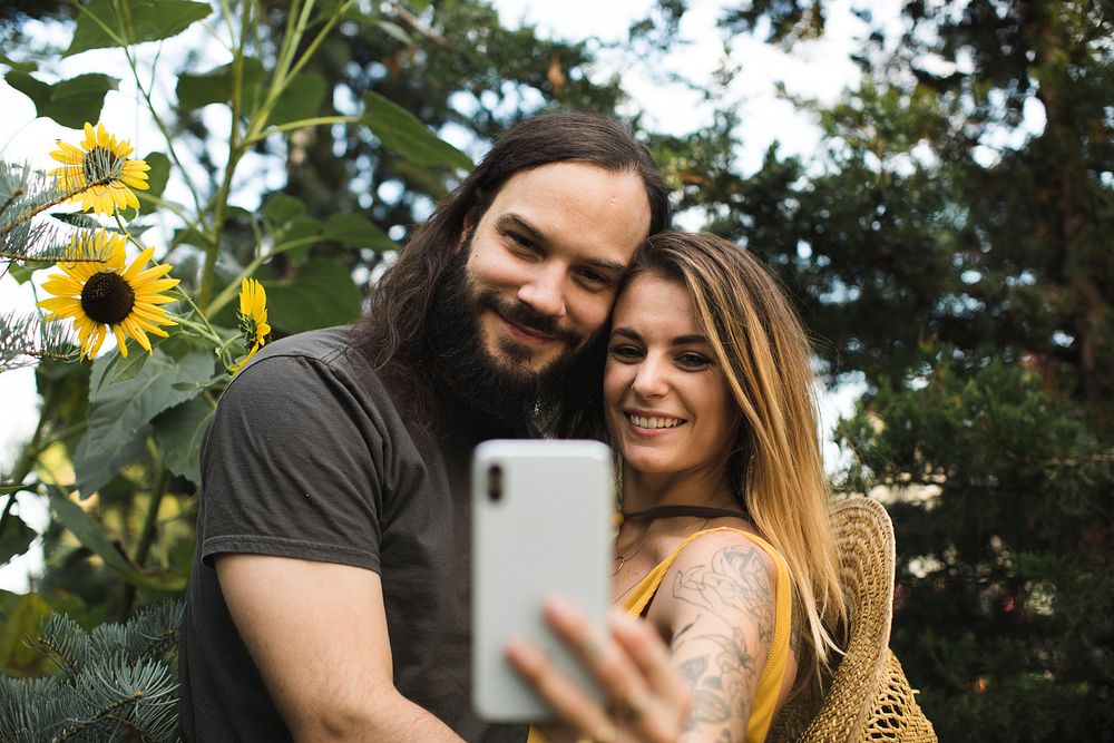 Couple taking a selfie with sunflowers