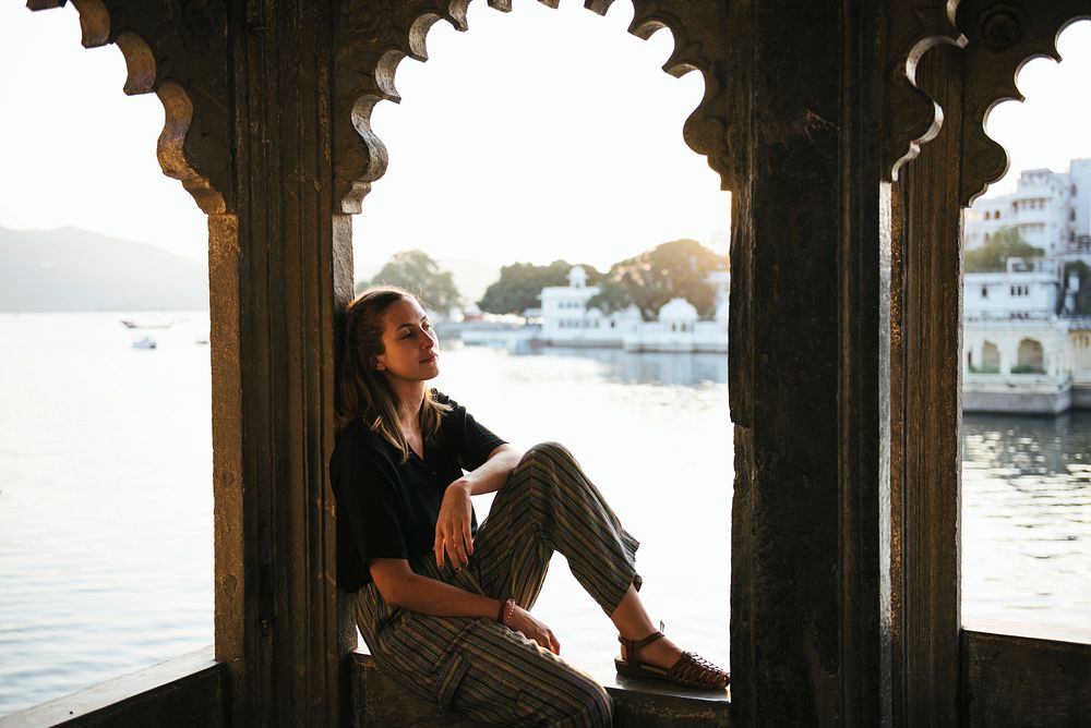 Western woman sitting on a cultural architecture in Udaipur, India