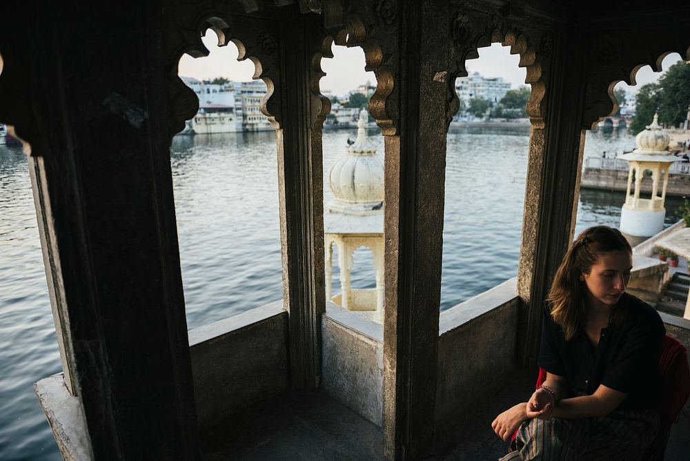 Western woman sitting on a cultural architecture in Udaipur, India
