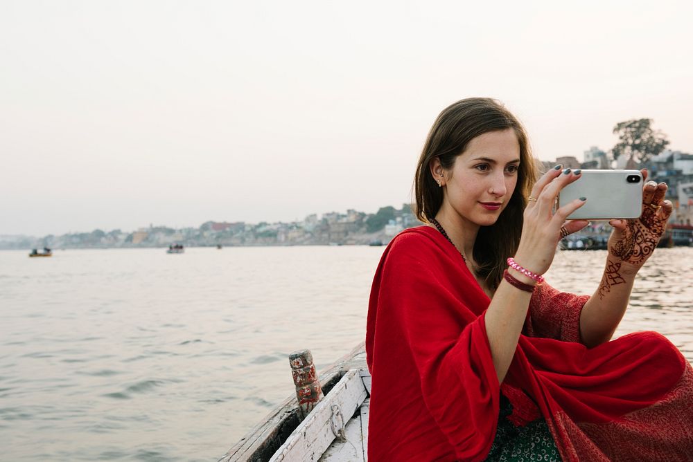 Traveler on a boat taking photos from the River Ganges