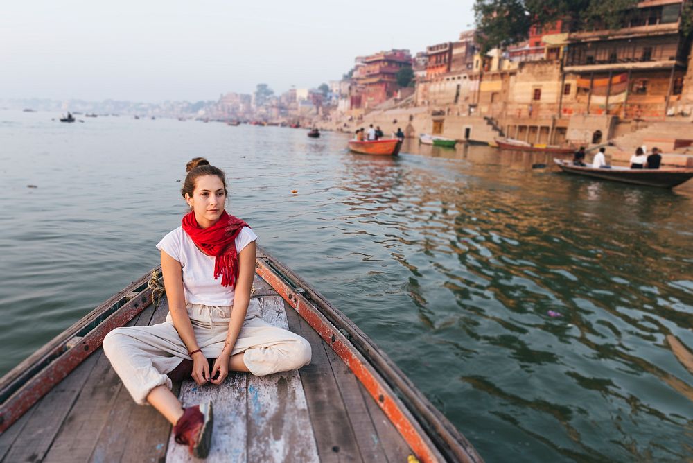 Western woman on a boat exploring the River Ganges
