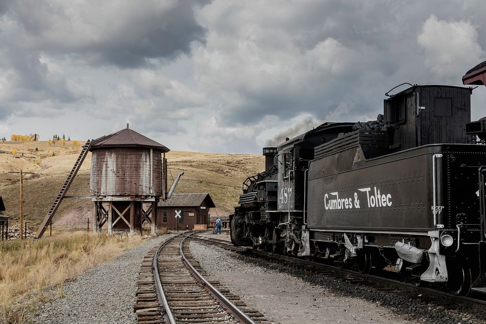 A water tower, steam engine, and tender at tiny Osier, Colorado, station about midway on the Cumbres & Toltec Scenic (C&TS)…