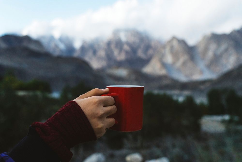 Woman holding a mug overlooking the Himalaya mountains