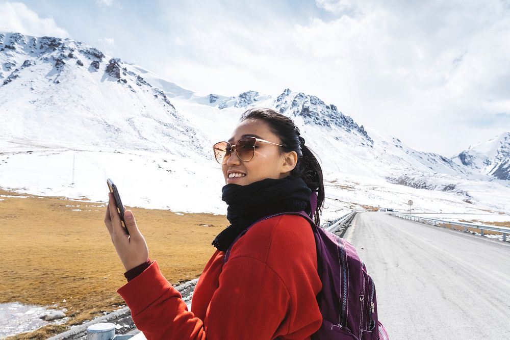 Young woman with a smartphone in the Himalaya mountains