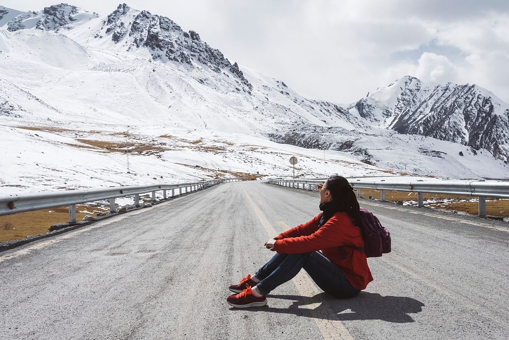 Young woman sitting on the Karakoram highway