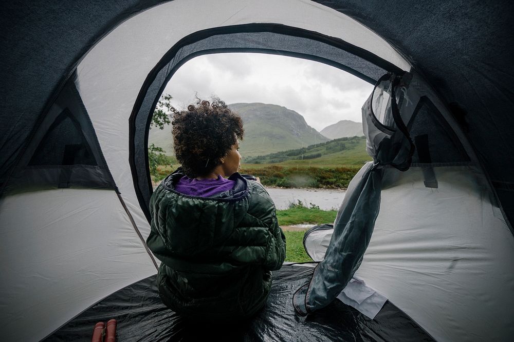 Woman sitting in a tent while it's raining