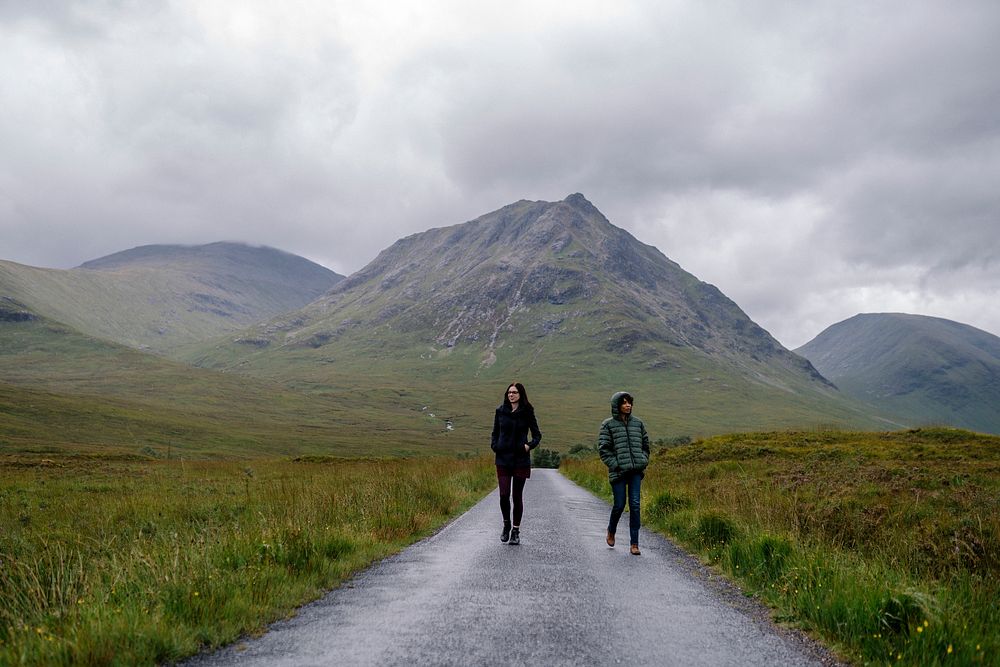 Couple of friends walking through the rain in Glen Etive, Scotland