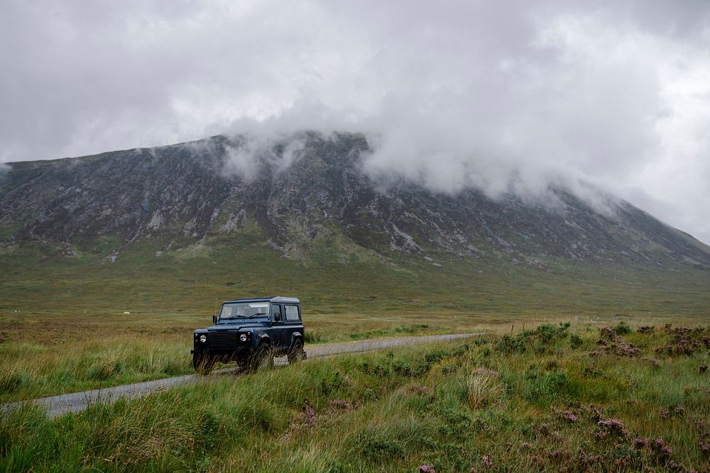 SUV on a road through the Scottish Highlands
