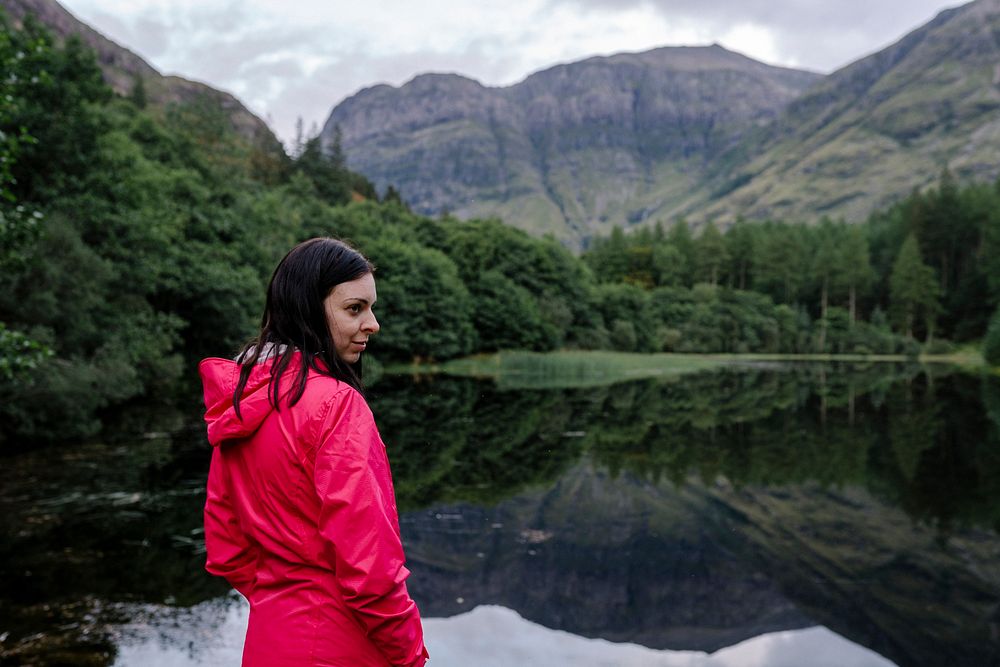 Woman standing by the riverside in the Highlands