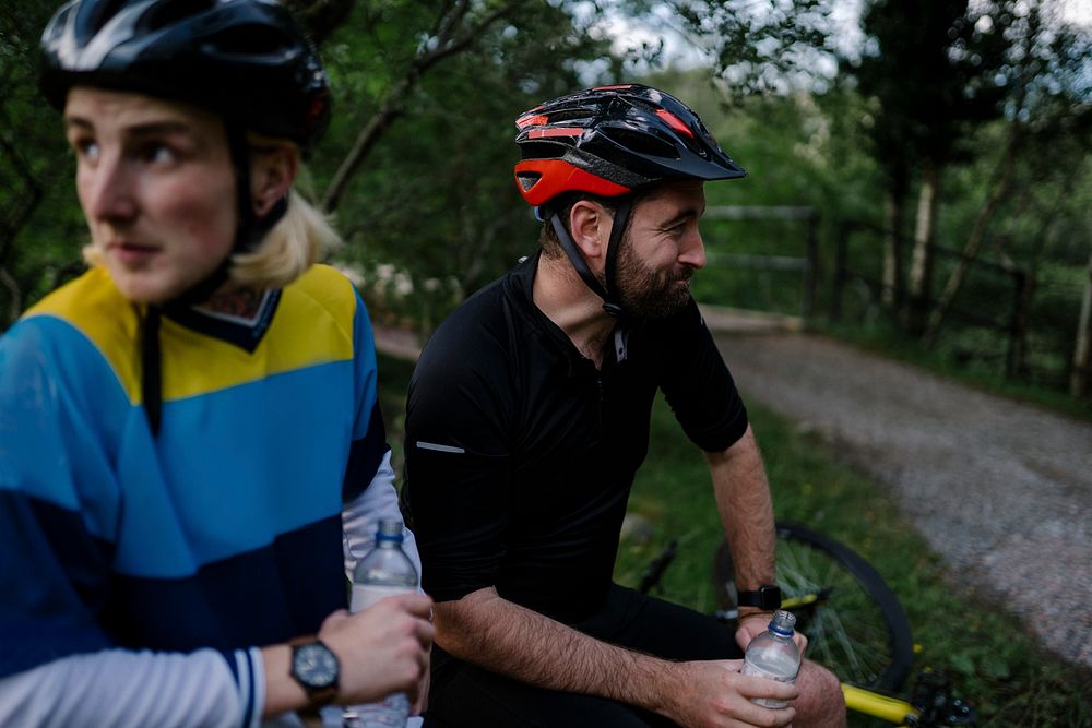 Cyclist resting and drinking water in the forest