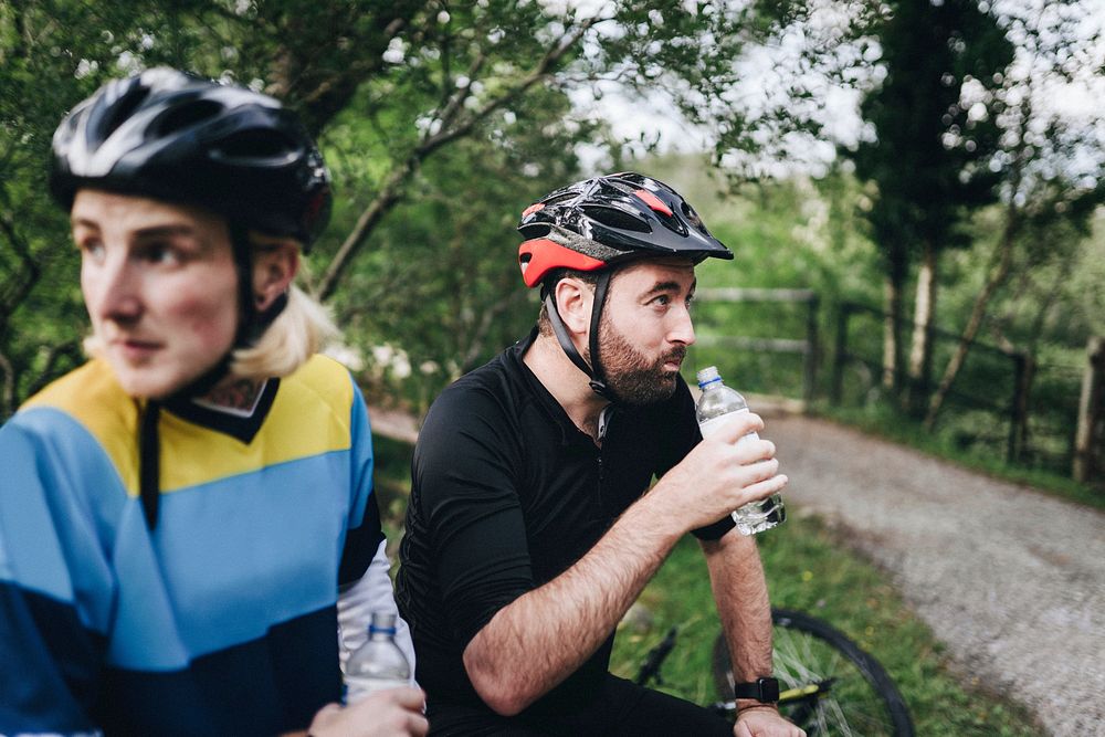 Cyclist resting and drinking water in the forest
