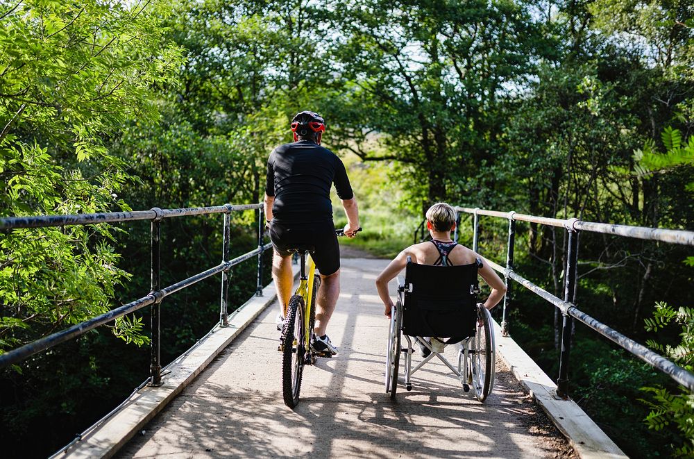 Couple on a exercising together on a bicycle and in a wheelchair