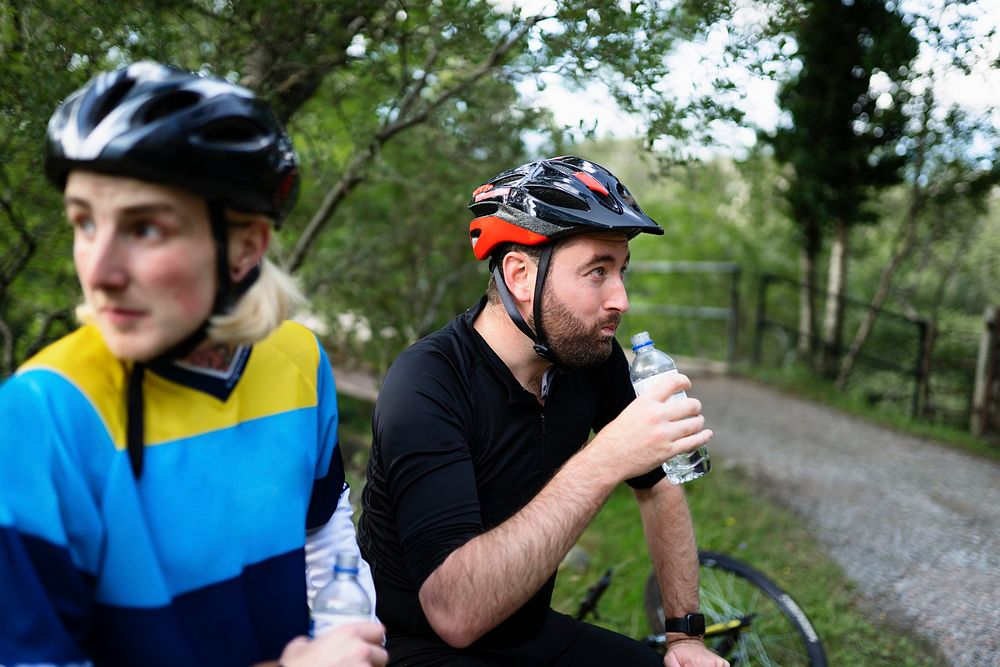 Cyclists resting and drinking water in the forest