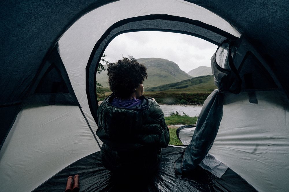 Woman sitting in a tent while it's raining