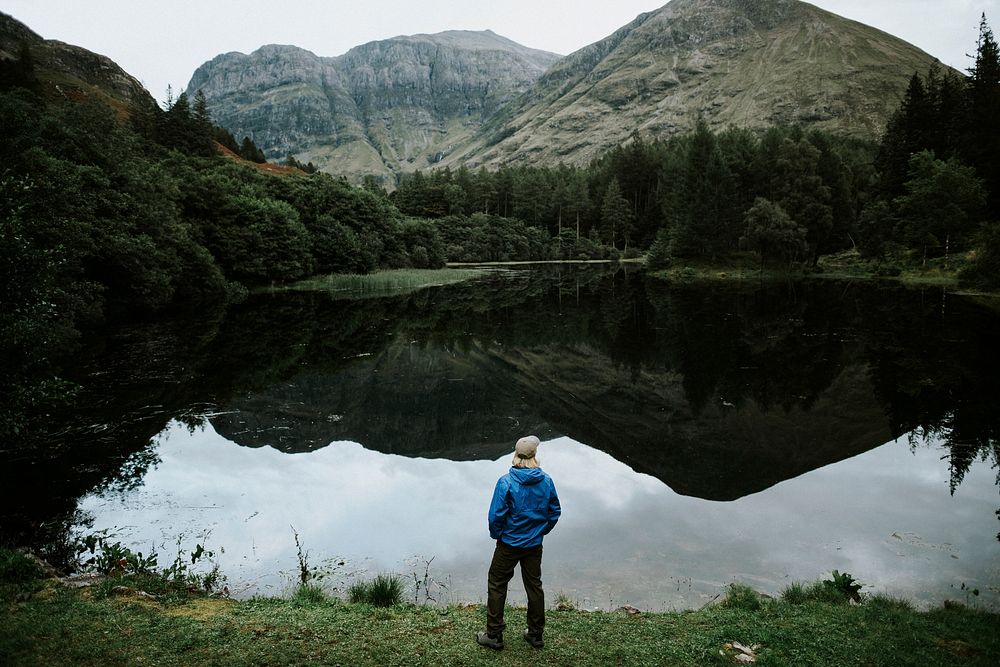 Man standing by the lakeside in the Highlands