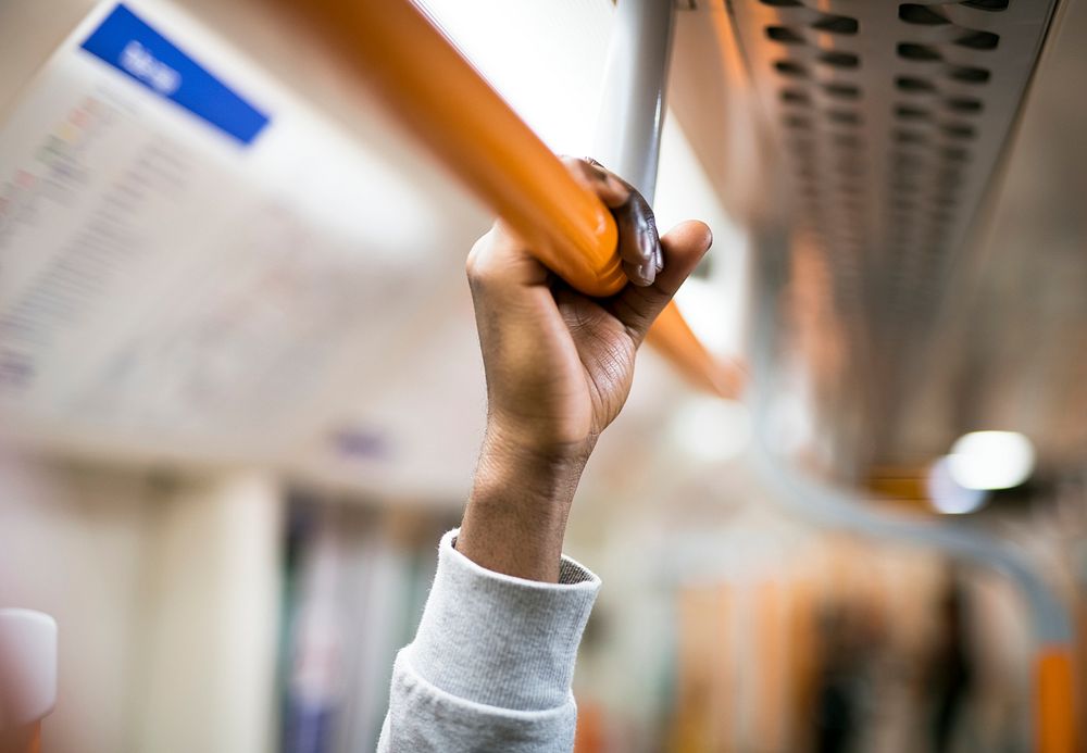 Man holding on to a handrail on a train