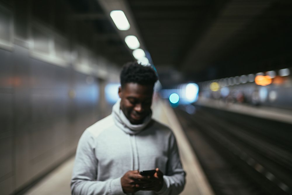 Man texting at a subway station