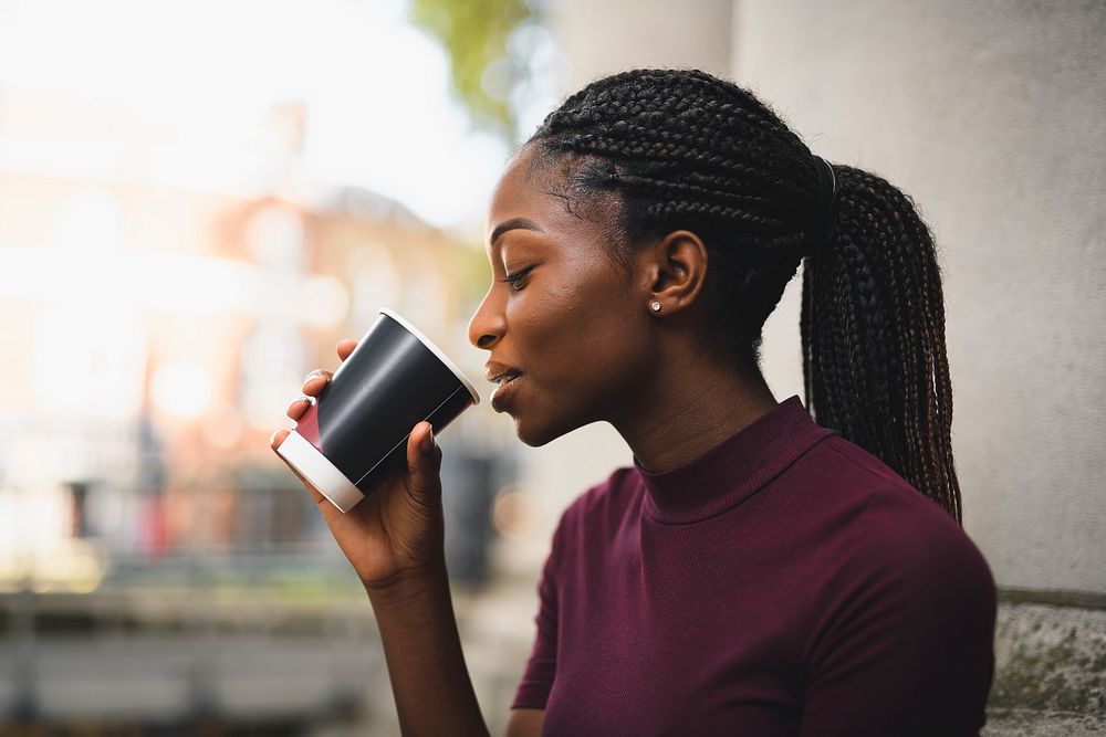 Woman with braids having a cup of hot coffee