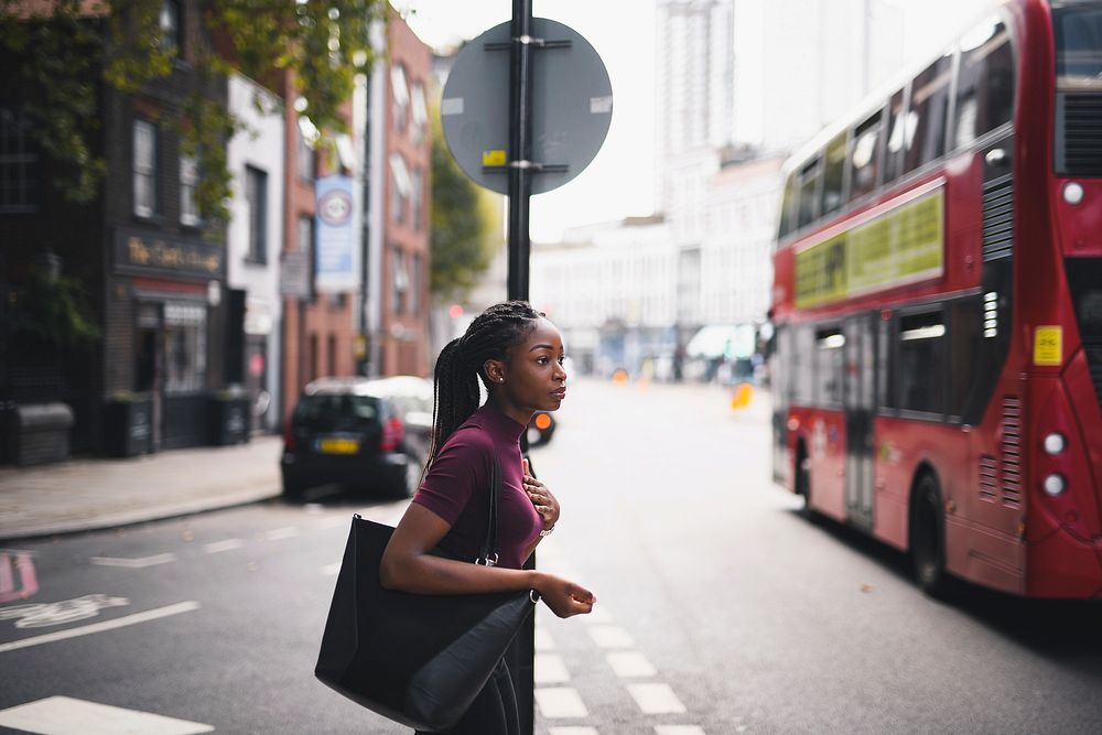 Woman with braids crossing a street in downtown London