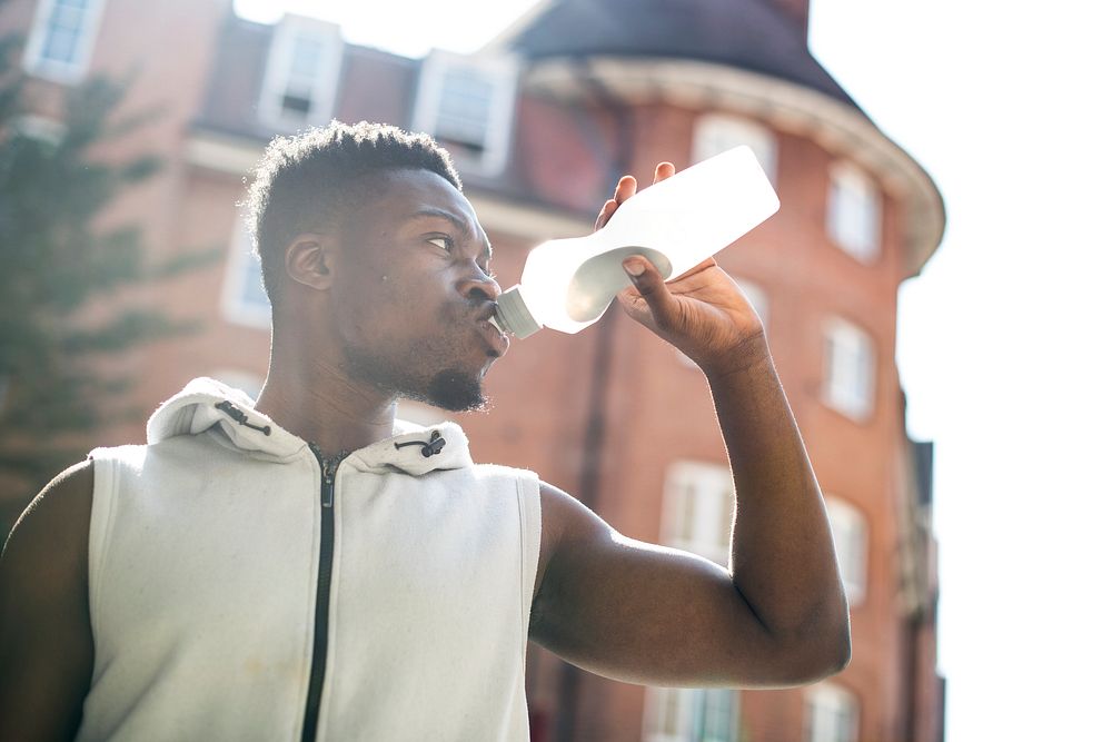 Athletic man drinking out of a sports bottle