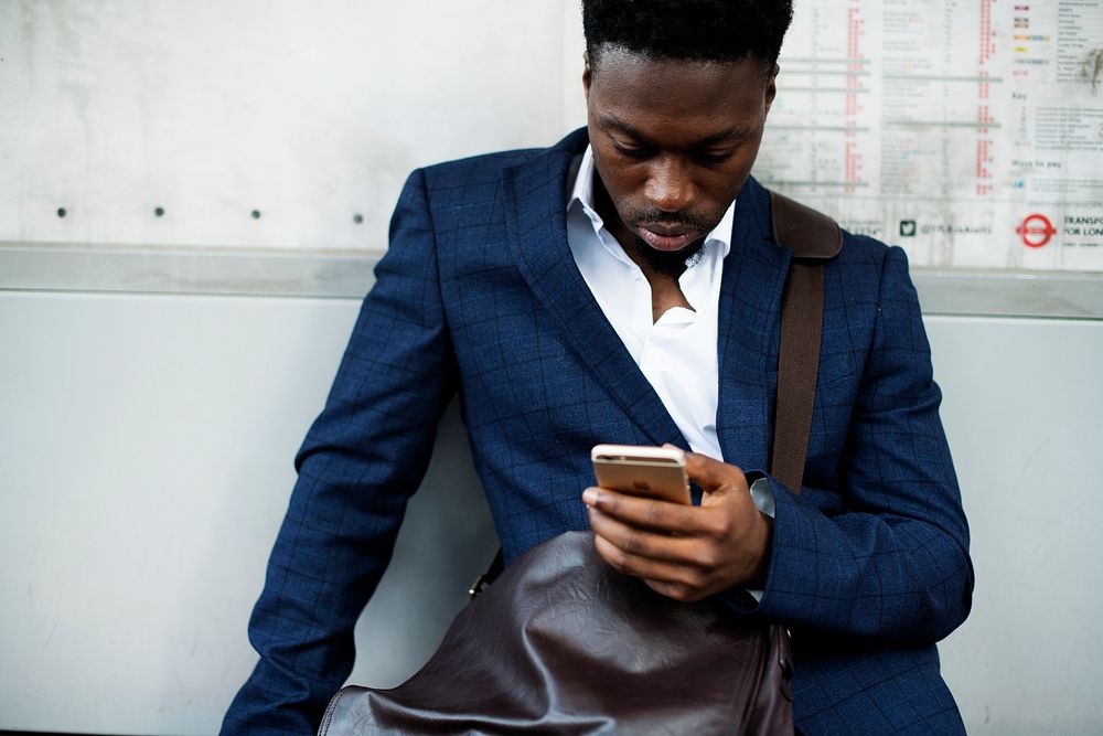 Man in a suit texting on his phone