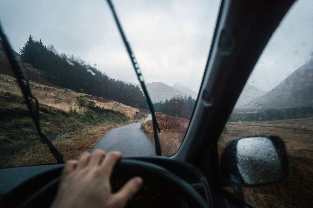 Man driving a car in the Highlands, Scotland