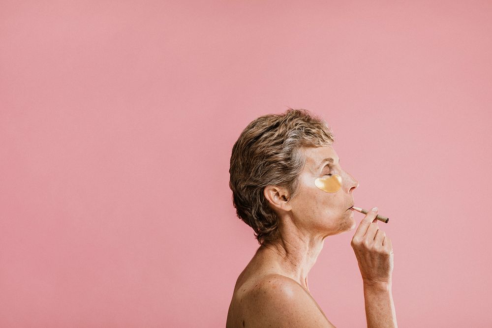 Woman wearing a golden eye mask and smoking cigars