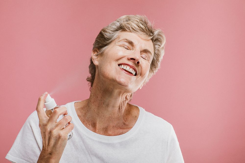 Elderly woman spraying cologne