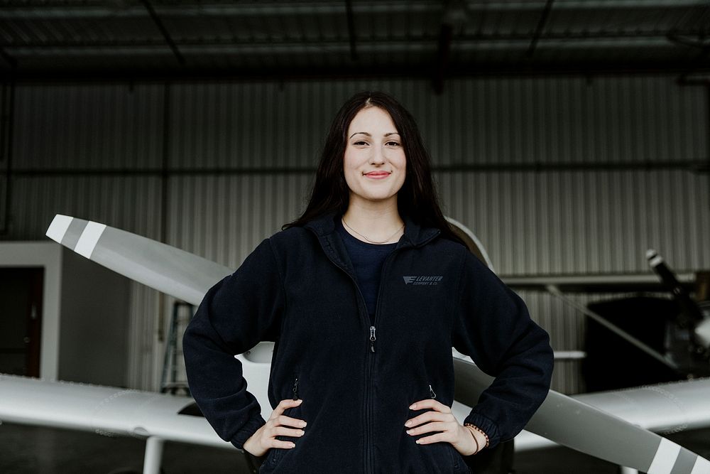 Happy confident airwoman in the hangar