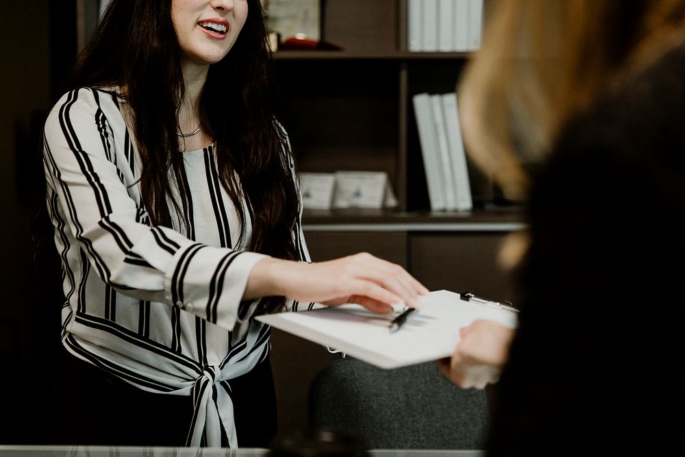 Woman handing over the contract to the customer