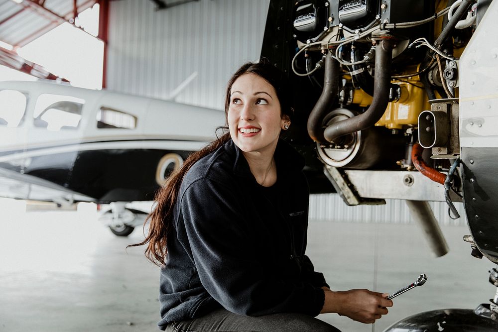 Female aviation technician repairing the motor