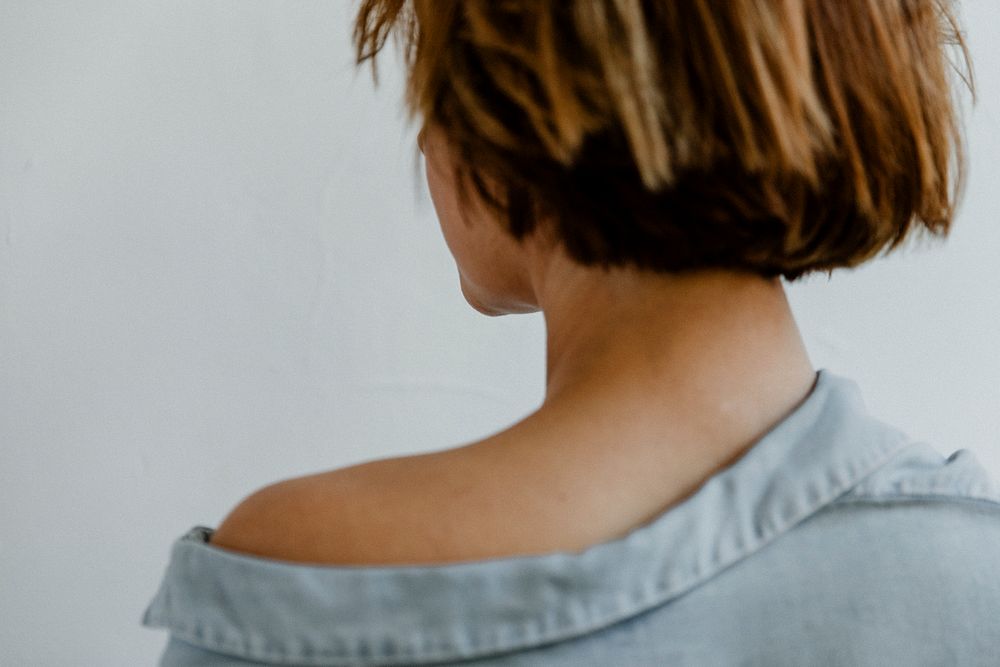 Rear view of a short dyed hair in a denim shirt