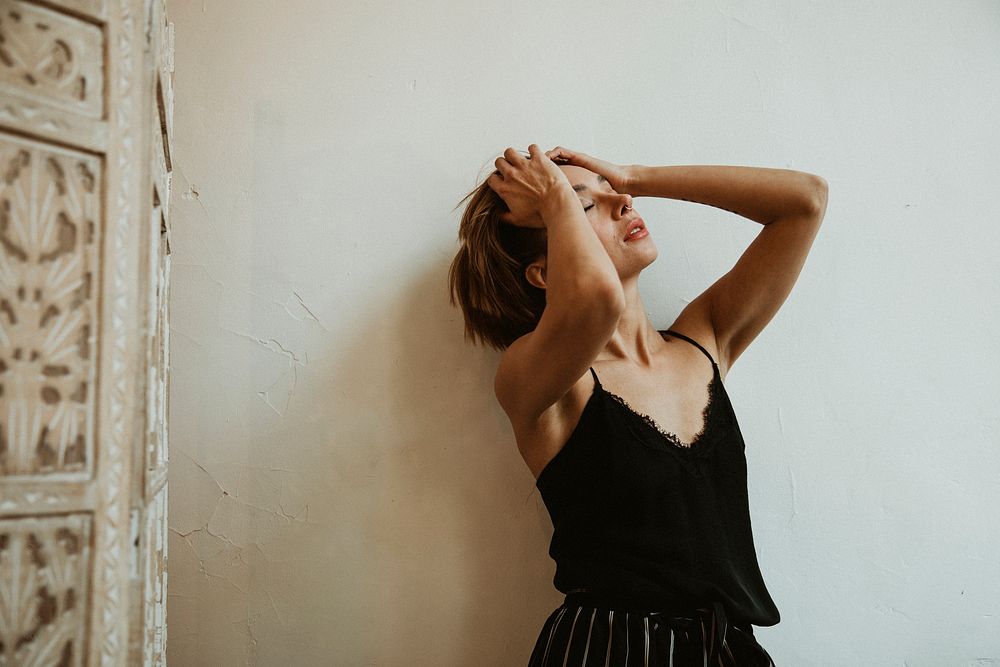 Serious lady running fingers through her hair