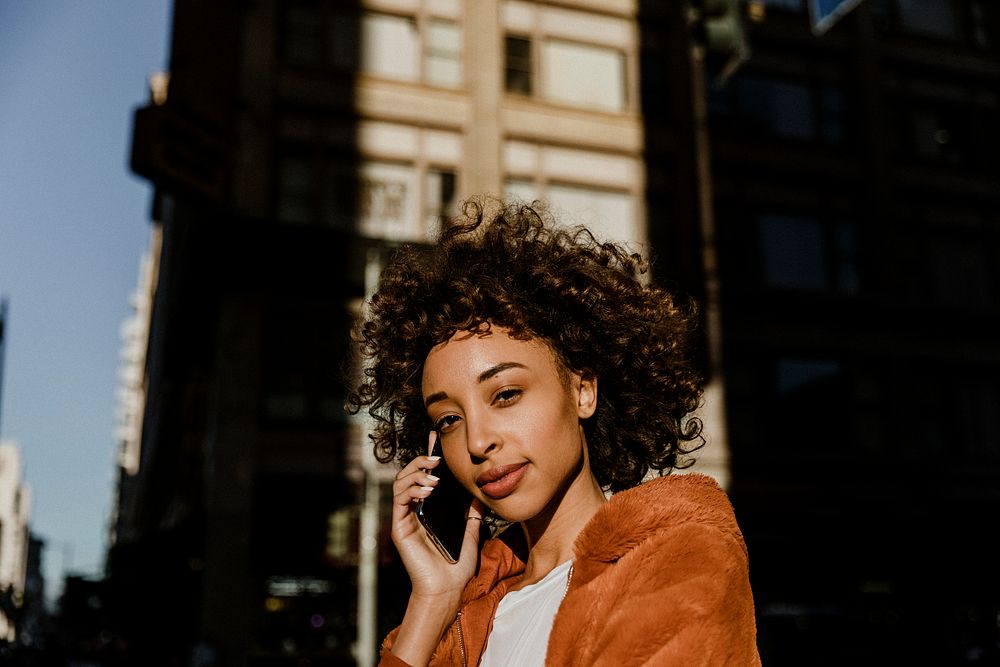 Black woman making a call in downtown