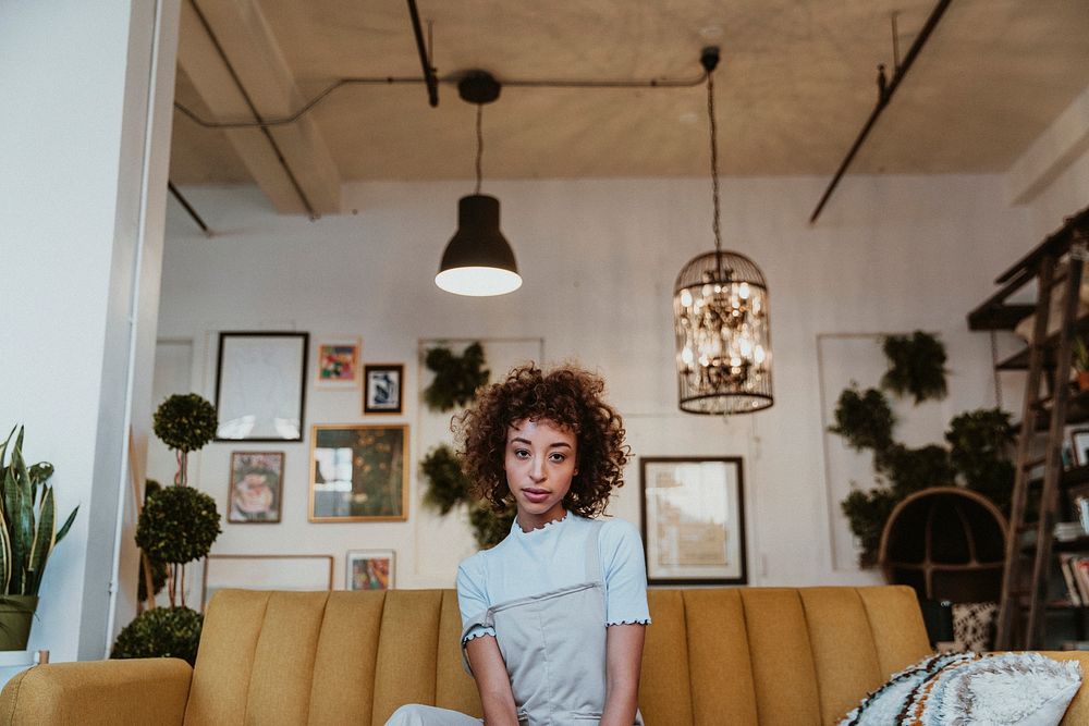 Woman sitting on a mustard yellow couch