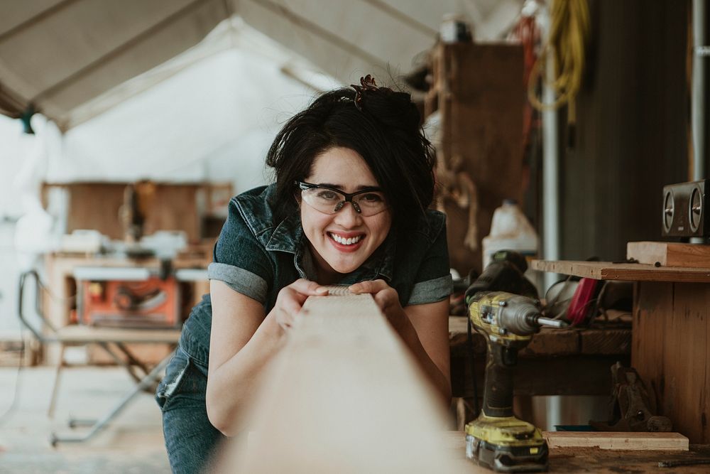 Female carpenter checking quality of her lumber