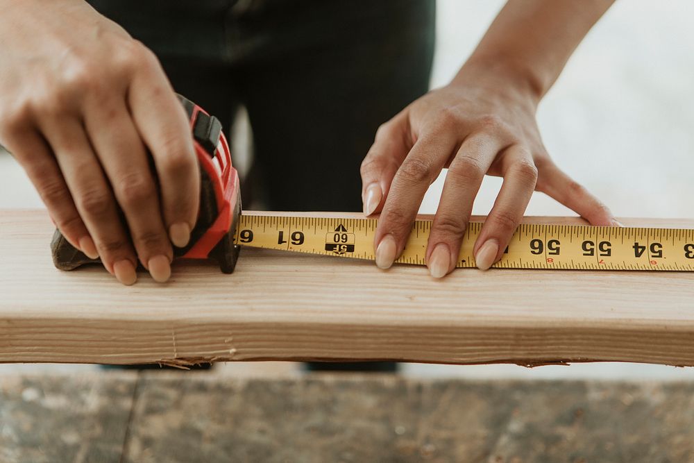Female carpenter measuring the lumber