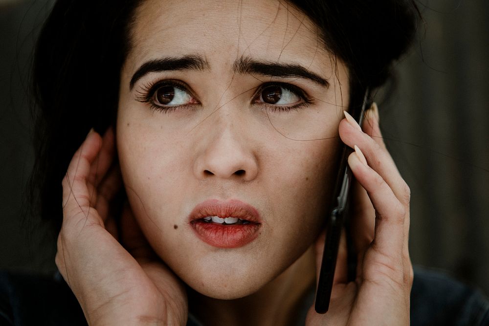 Female carpenter talking on a phone with worries