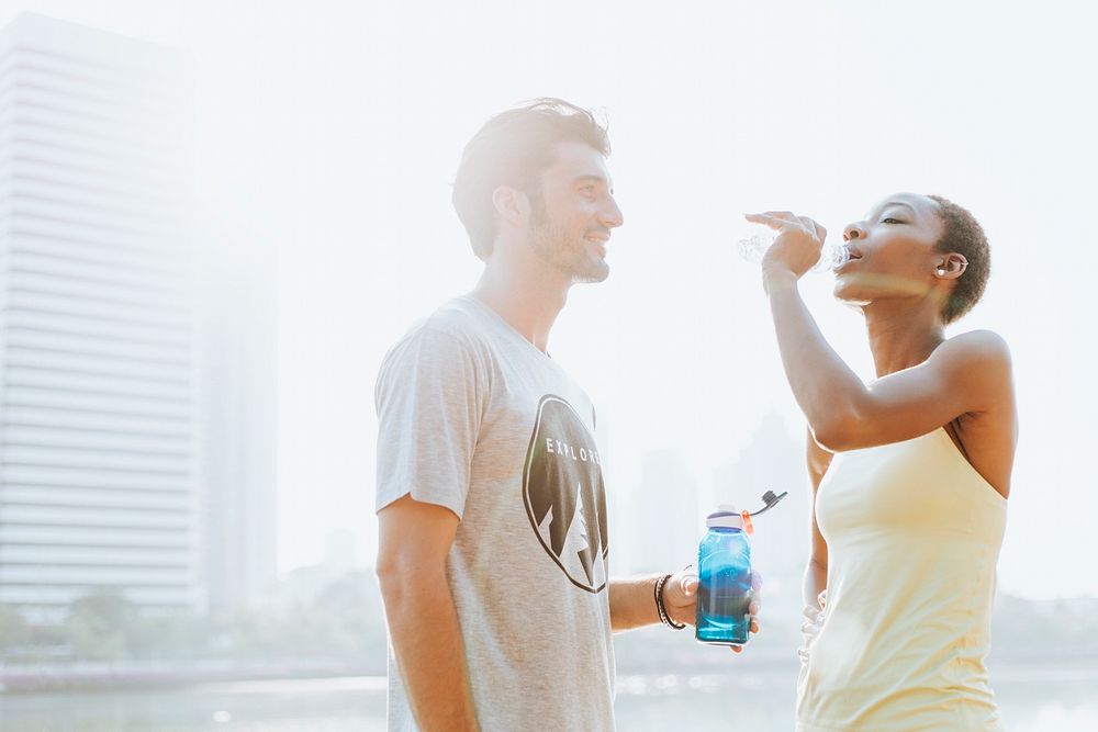 Fitness couple drinking water after workout