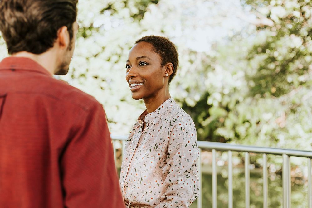 Man talking to a black lady in a park