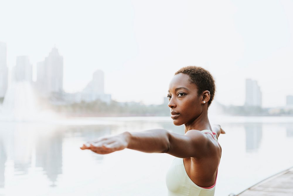 Black lady doing a virabhadrasana pose