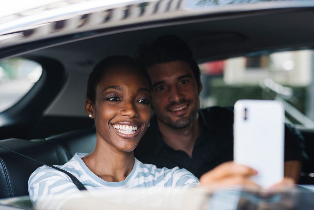 Happy and loving couple taking a selfie in a car