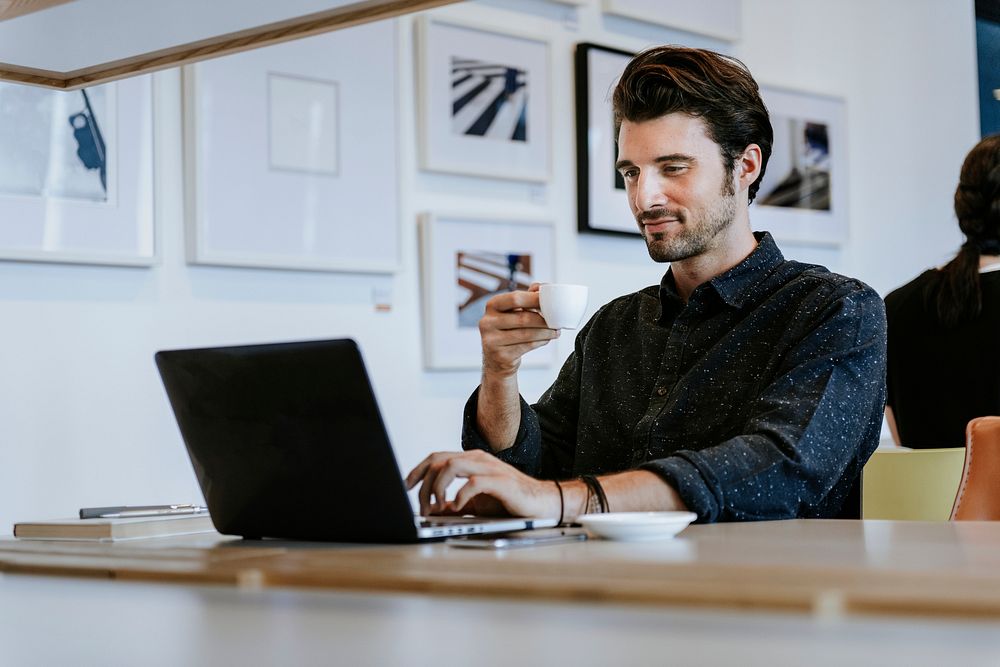 Man drinking coffee while working