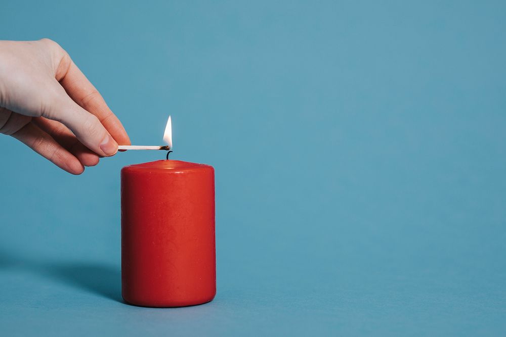 Woman lighting a red candle