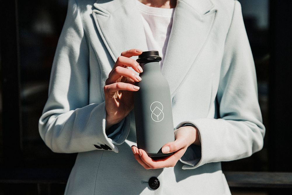 Woman holding a gray stainless steel bottle