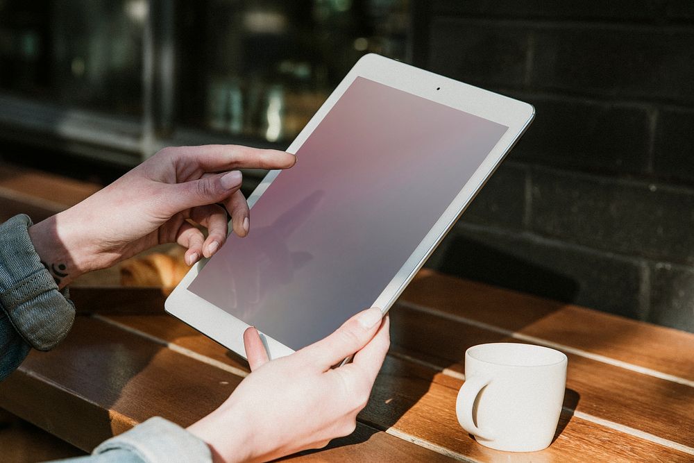 Woman using a digital tablet in a cafe mockup